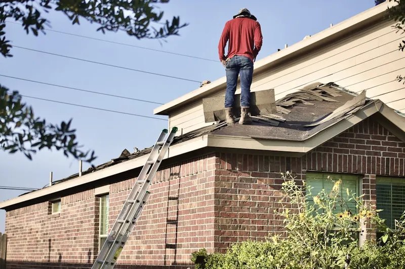 Professional roofer working on a residential roof in North Benton Station